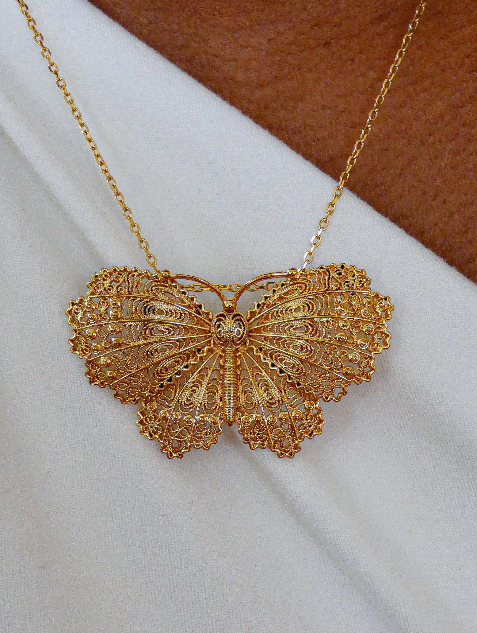 Collier papillon doré filigrane.