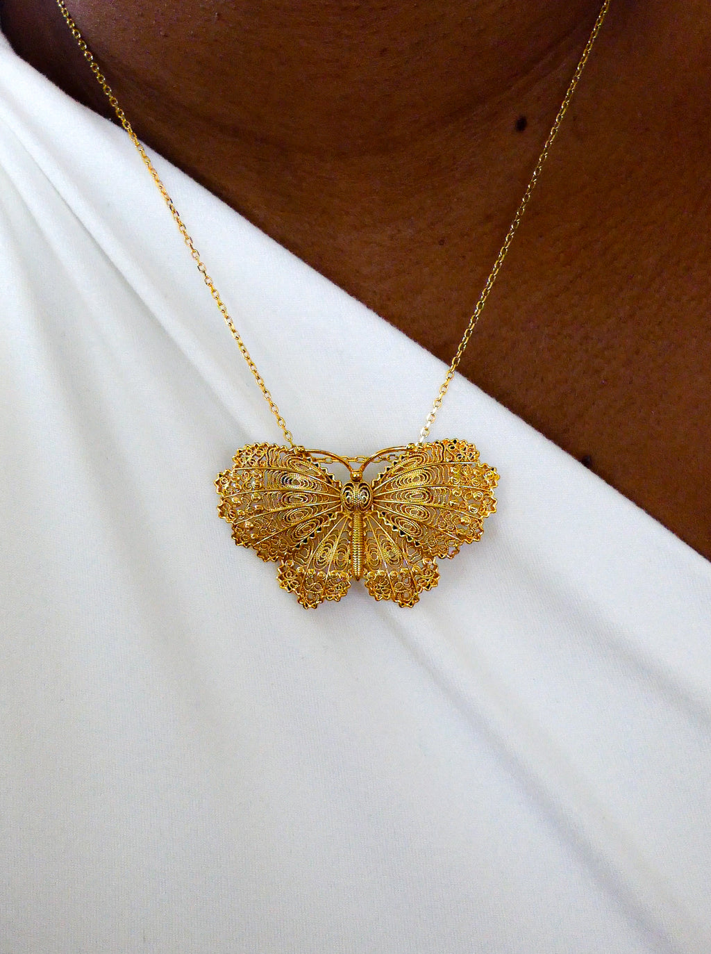 Collier papillon doré filigrane.