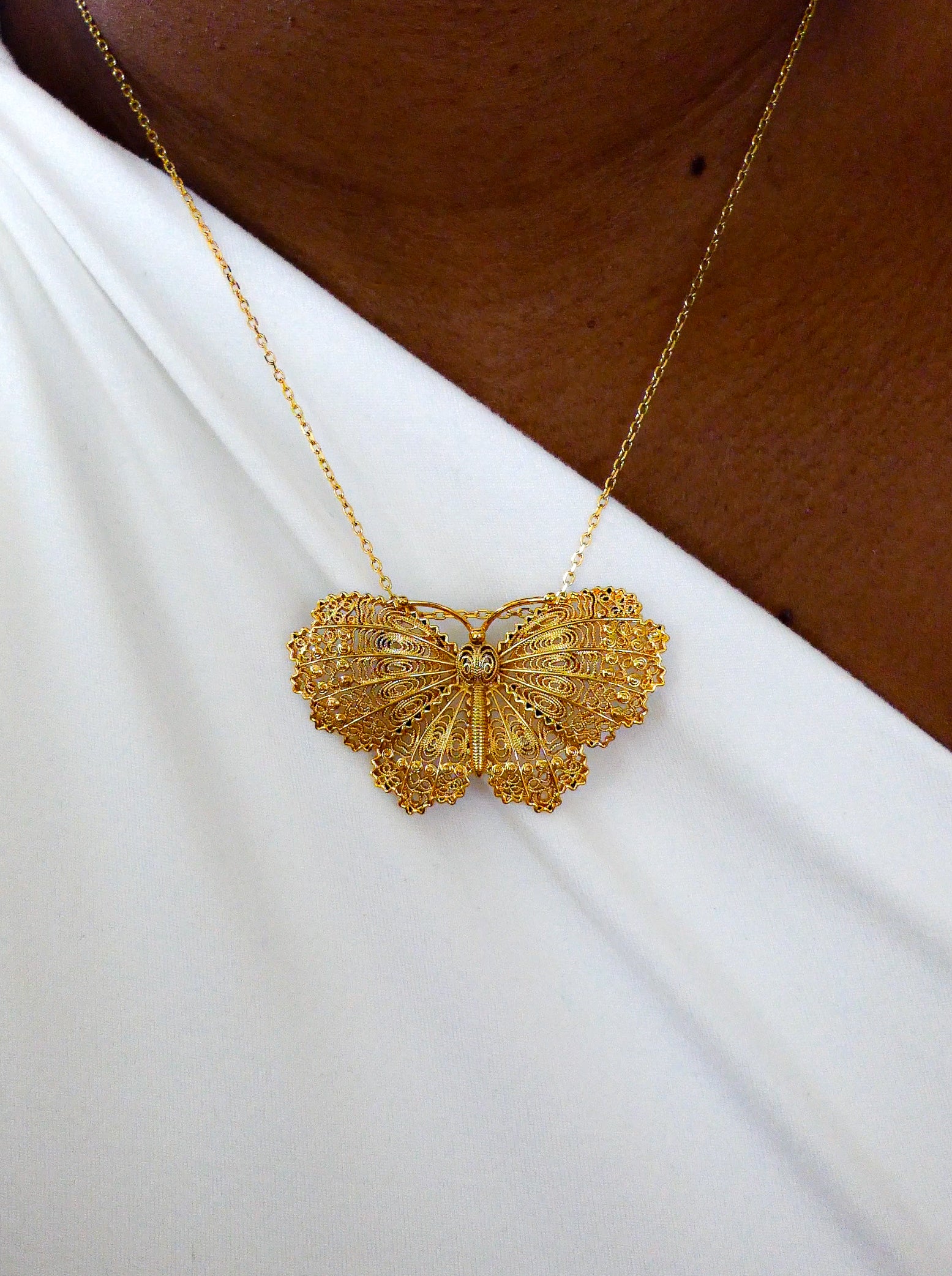 Collier papillon doré filigrane.